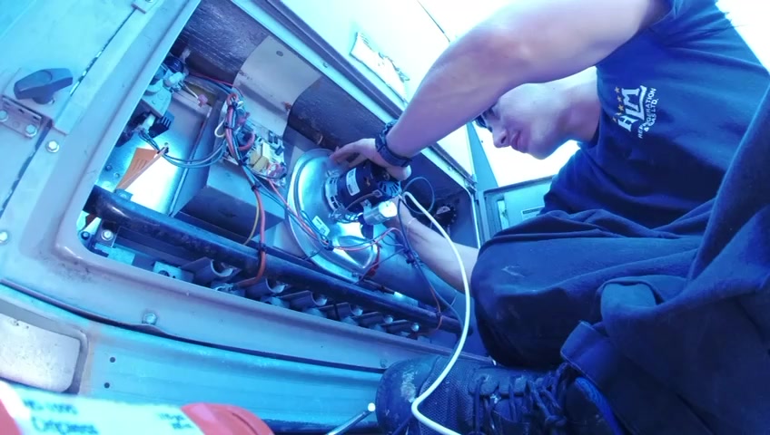 HLM technician working inside an HVAC unit